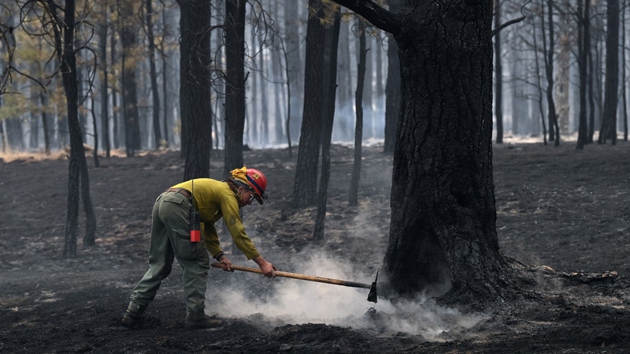 A firefighter works on a New Mexico fire