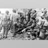 American assault troops receive medical aid in Normandy while they rest.