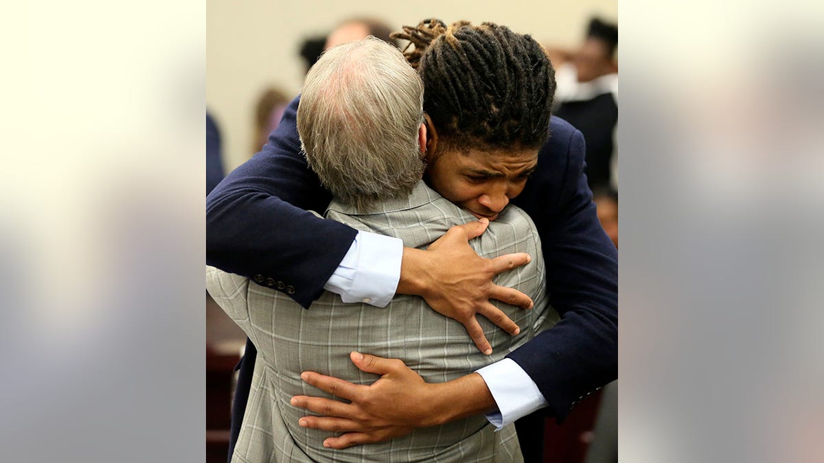 Former Virginia Tech football player Isimemen Etute hugs defense attorney after acquittal