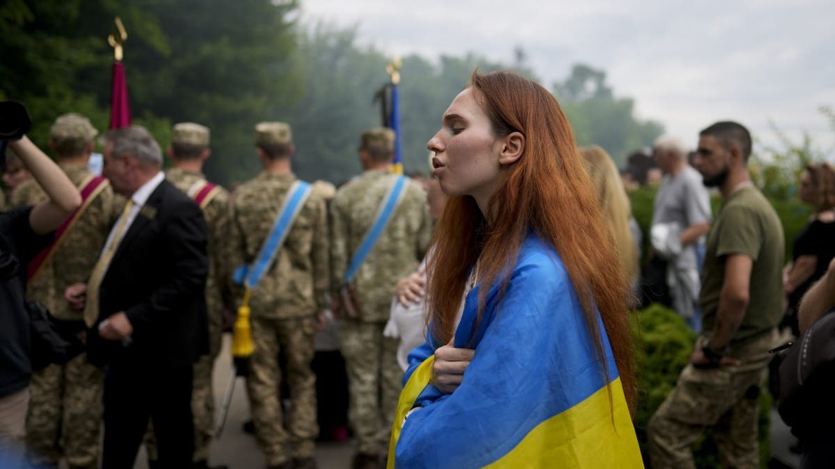Woman wrapped in Ukrainian flag