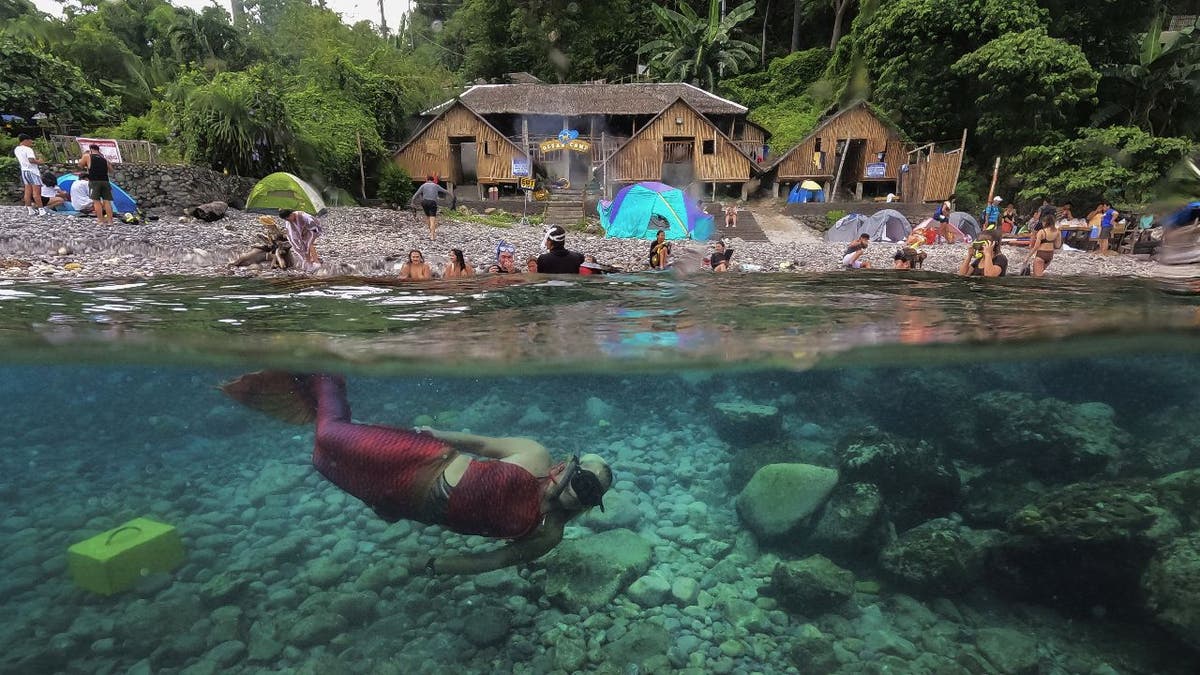 Mermaid instructor Queen Pangke Tabora swims in ocean