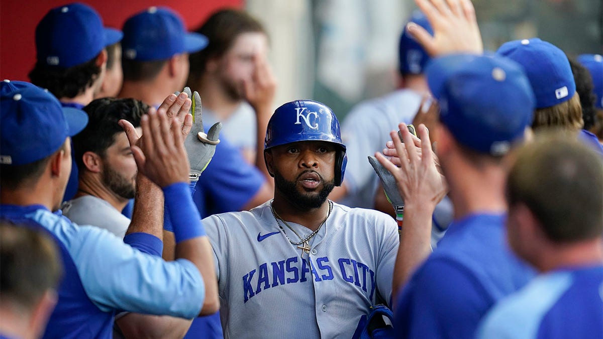 Carlos Santana high-fives teammates in the dugout