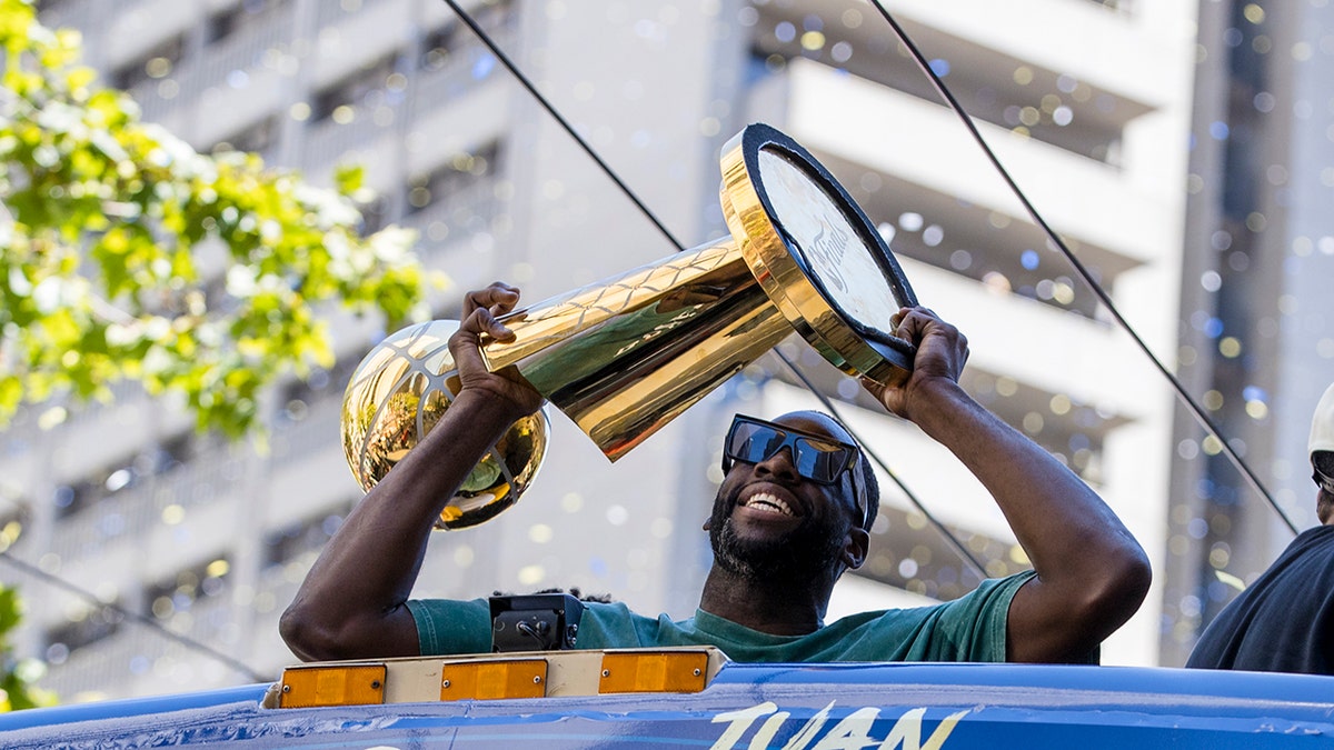 Draymond Green holds the Larry O'Brien trophy