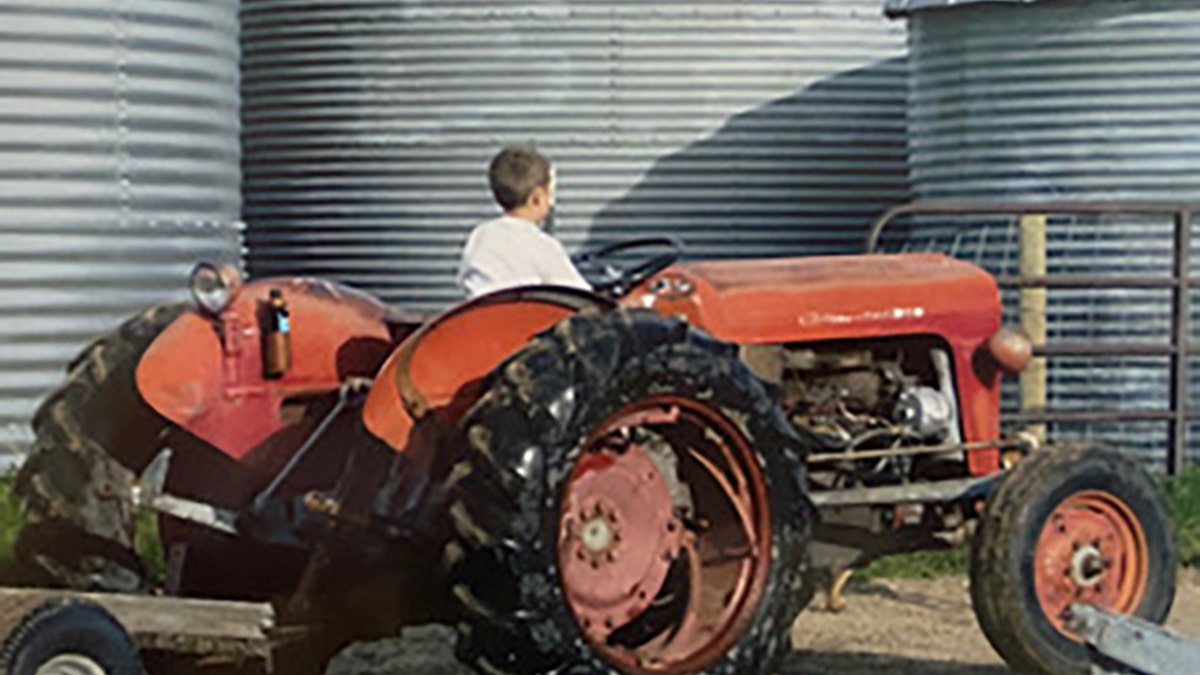 Dylan Rounds driving a Tractor as a child