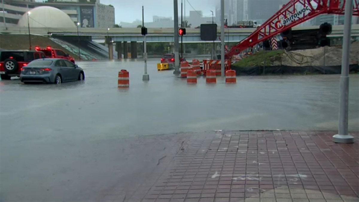 Miami vehicles drive through flooded streets