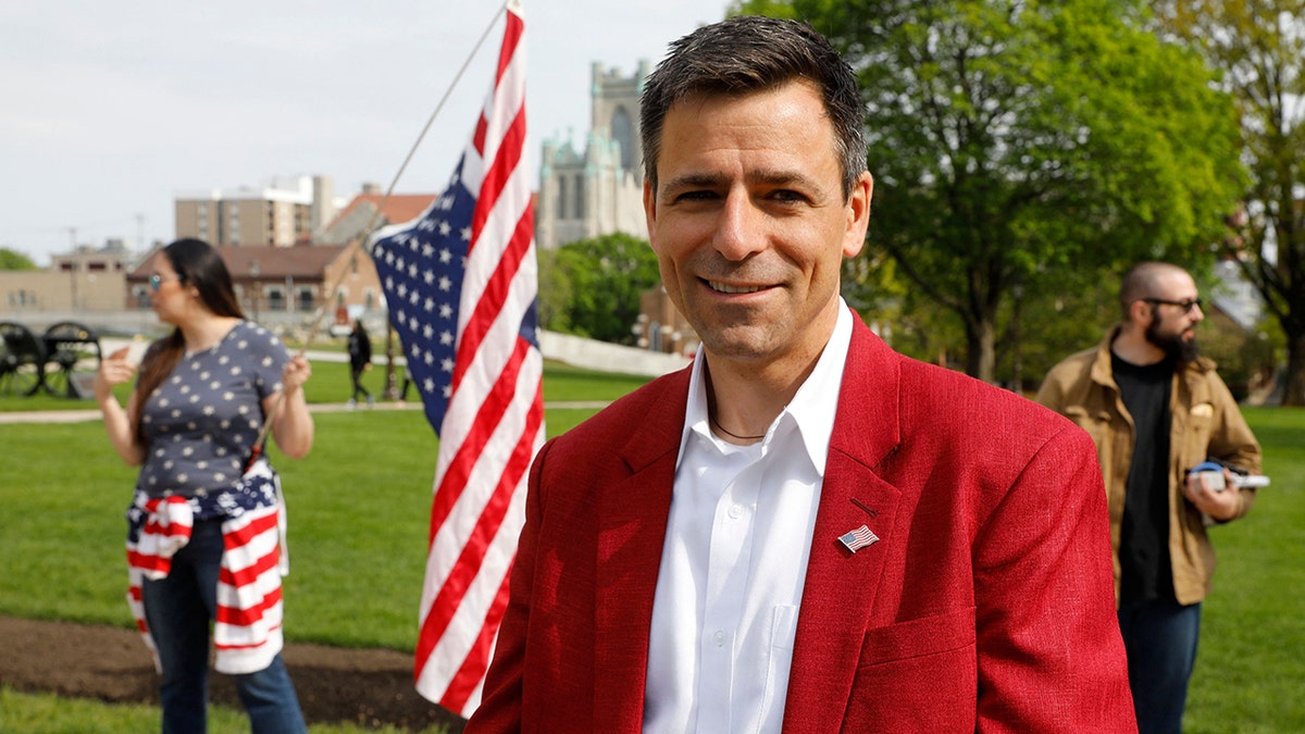 Michigan Republican gubernatorial candidate Ryan Kelley stands by flag