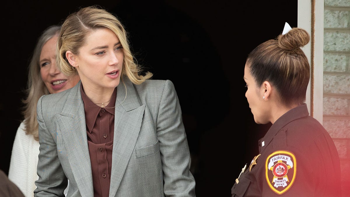 Amber Heard speaks with Fairfax County deputy outside courthouse