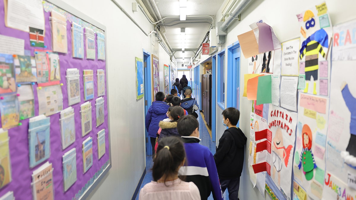 NYC schoolchildren walk down hallway