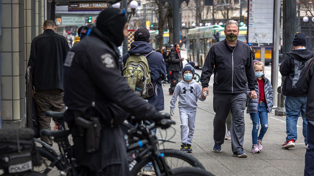 Seattle police officer on bike as children walk past