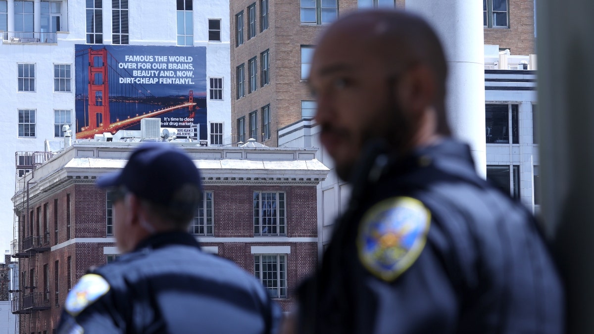San Francisco police officers look on near a new controversial billboard that warns against fentanyl on April 04, 2022 in San Francisco, California.