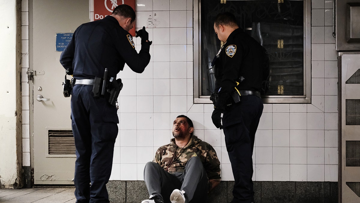 NYPD officers speak to homeless man