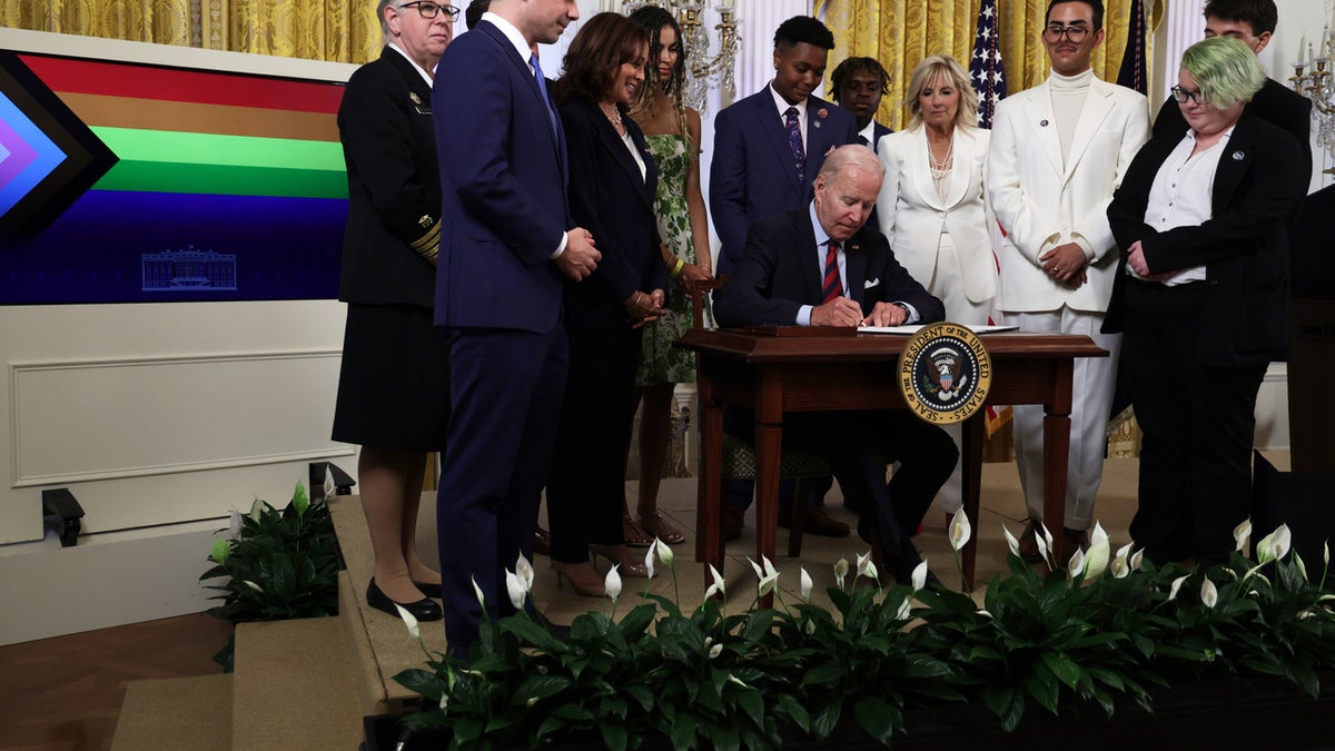 President Joe Biden signs an executive order on behalf of LGBTQI+ individuals