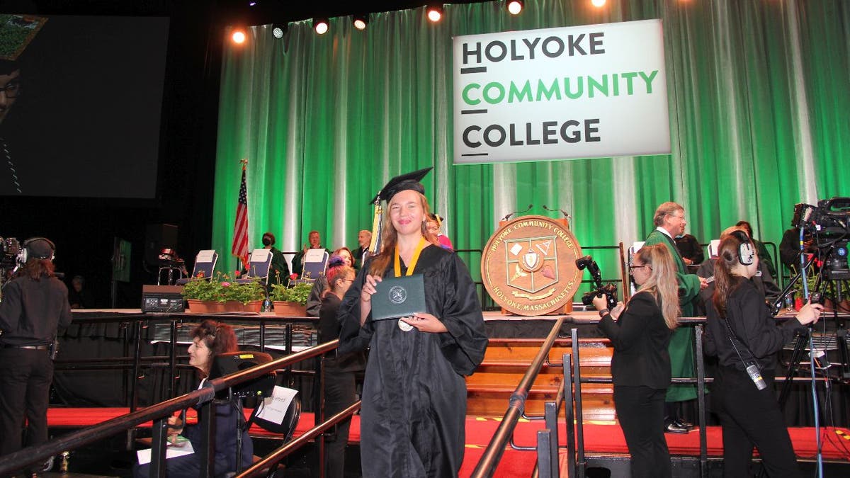 Alina Antropova holds her diploma cover at Holyoke Community College graduation.