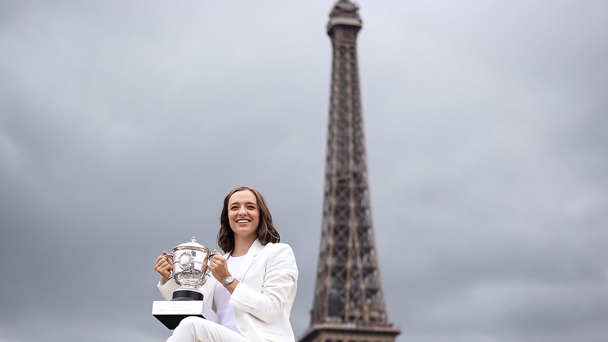 Iga Swiatek poses with French Open trophy in front of Eiffel Tower