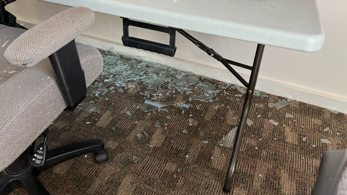 Glass beneath broken window to Walberg campaign and Jackson Right to Life's shared office.