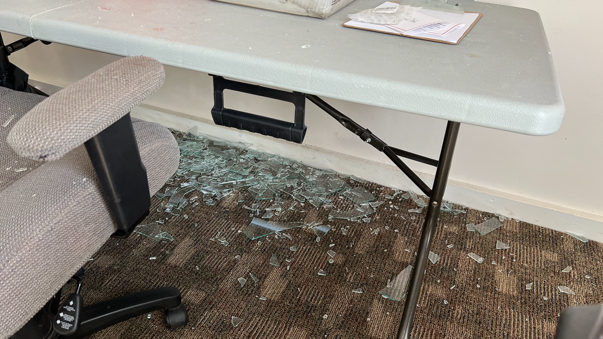 Glass beneath broken window to Walberg campaign and Jackson Right to Life's shared office.