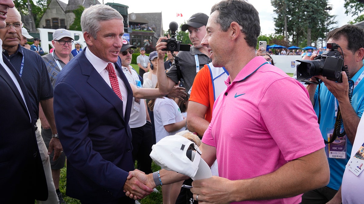 Rory McIlroy shakes hands with Jay Monahan