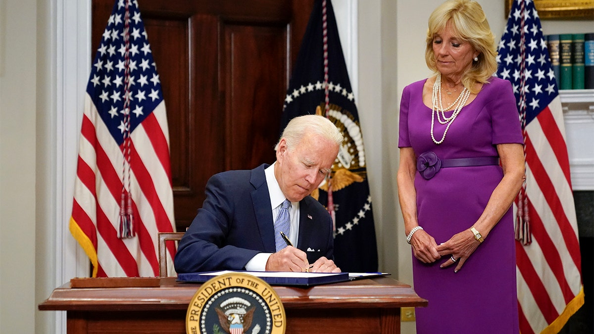 Joe Biden signing a gun bill into law beside Jill Biden