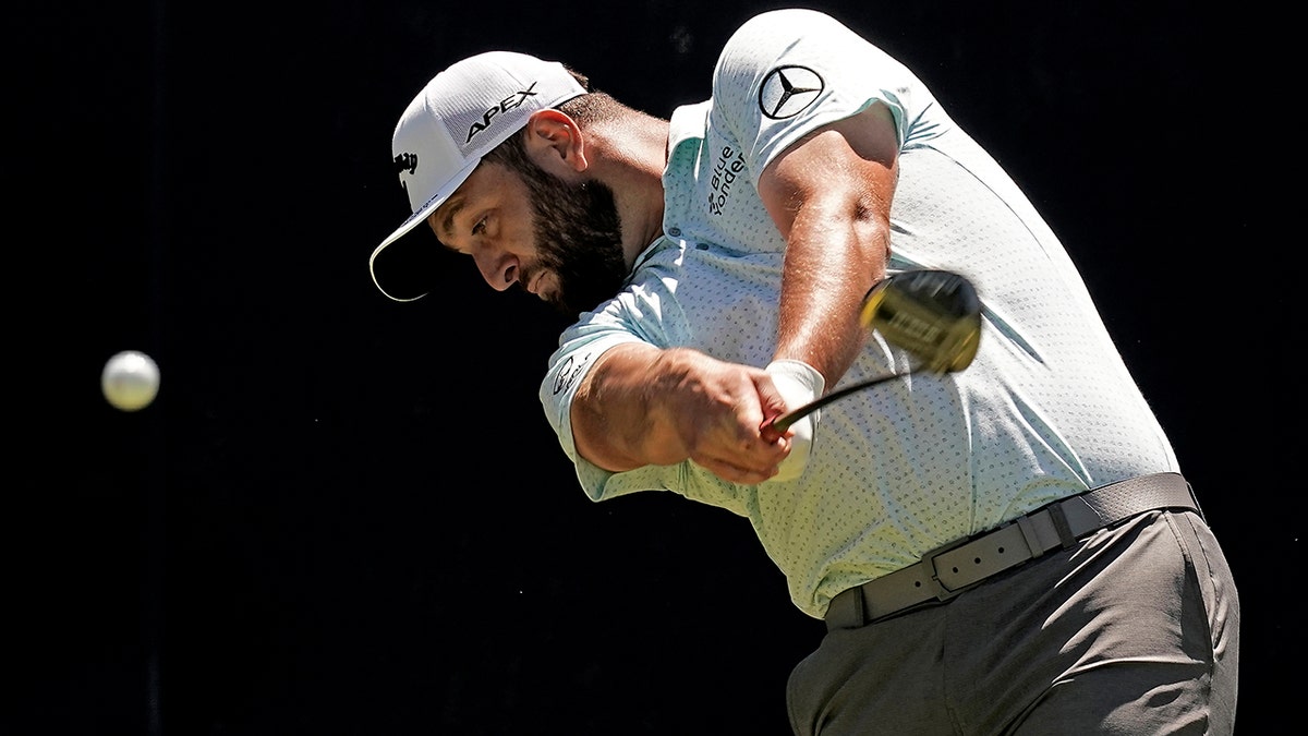 Jon Rahm swings a club