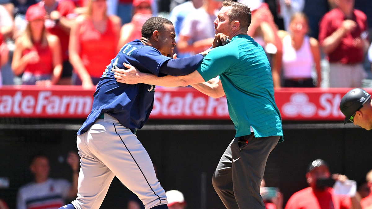 Julio Rodriguez held back by a Mariners coach