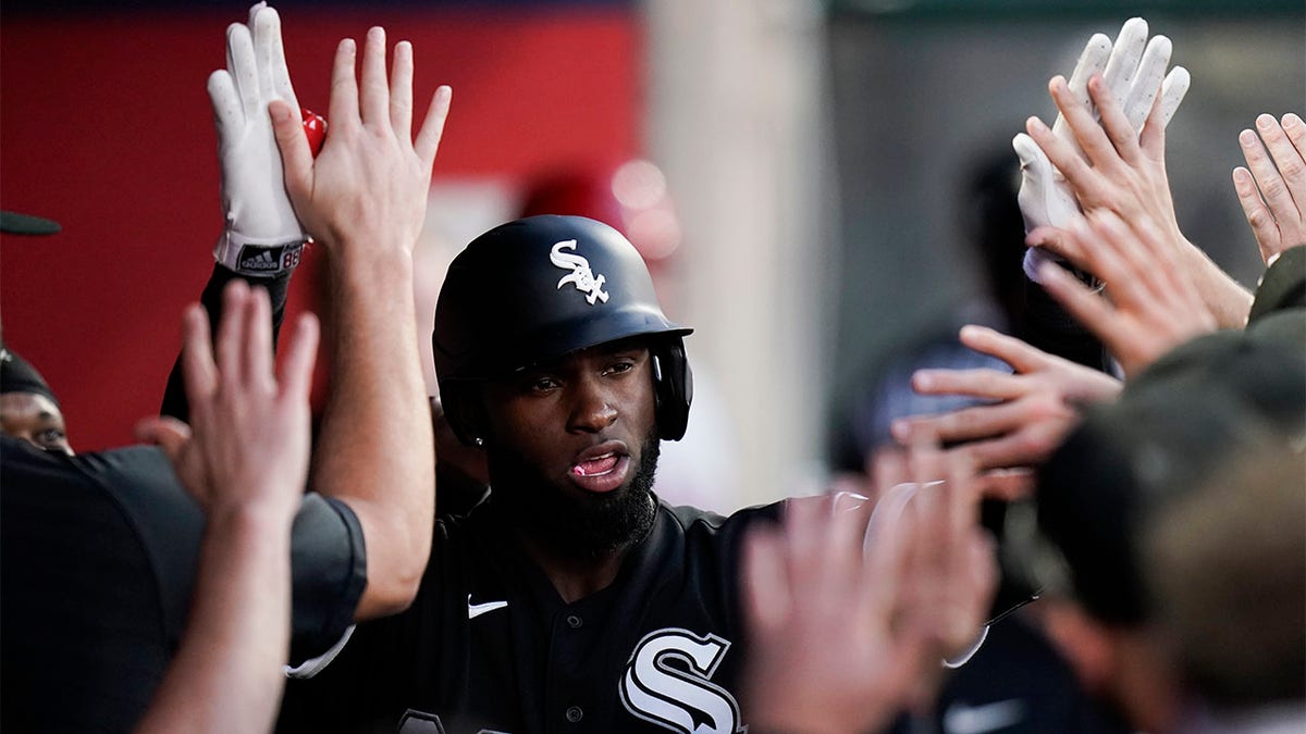 Luis Robert high fives teammates in dugout