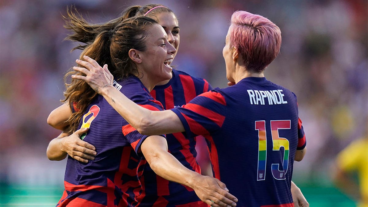 Megan Rapinoe hugs Alex Morgan and Sofia Huerta