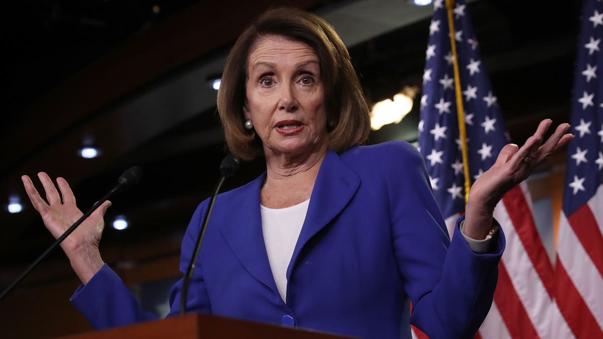 Nancy Pelosi speaks at podium with American flag in the background