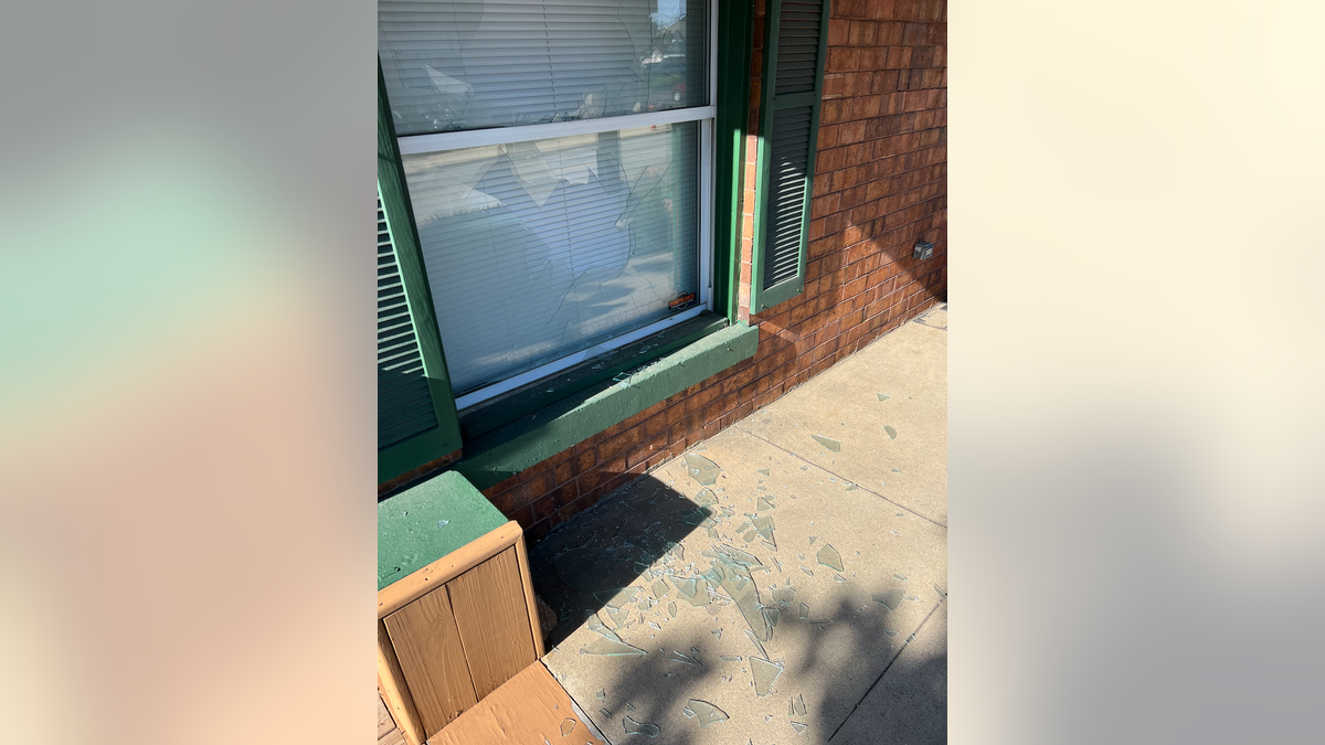 Outside of broken window to Walberg campaign and Jackson Right to Life shared office