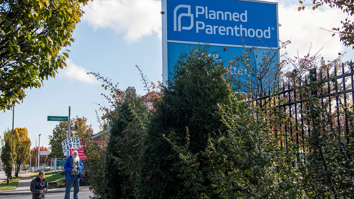 Planned Parenthood protesters pray outside Columbus location with sign reading "Jesus Saves"