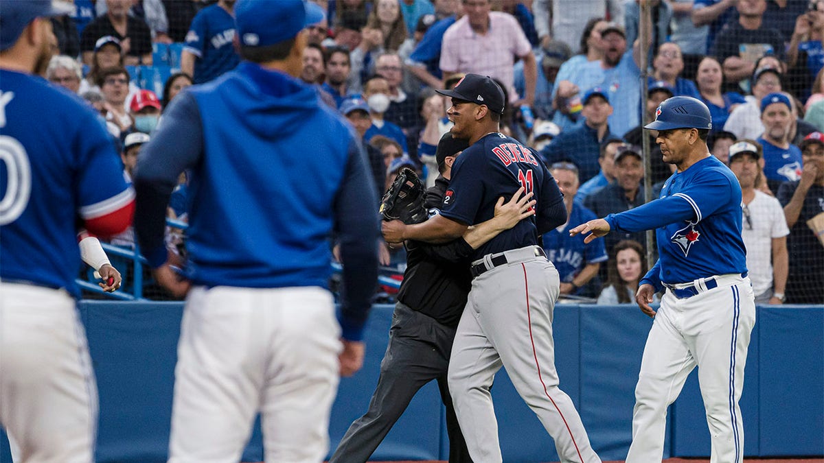 Rafael Devers being held back by un umpire