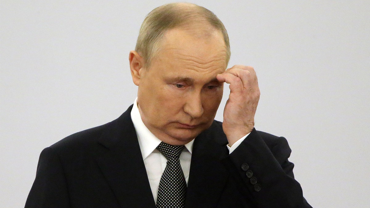 Russian President Vladimir scratches head in a suit