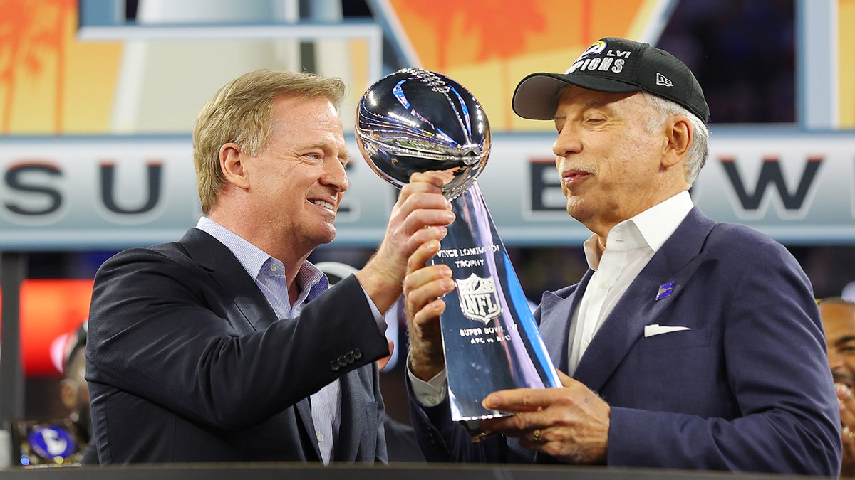 Stan Kroenke raises a Super Bowl trophy