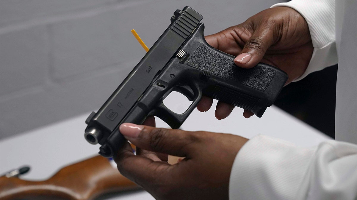 Photo of woman's hands holding handgun