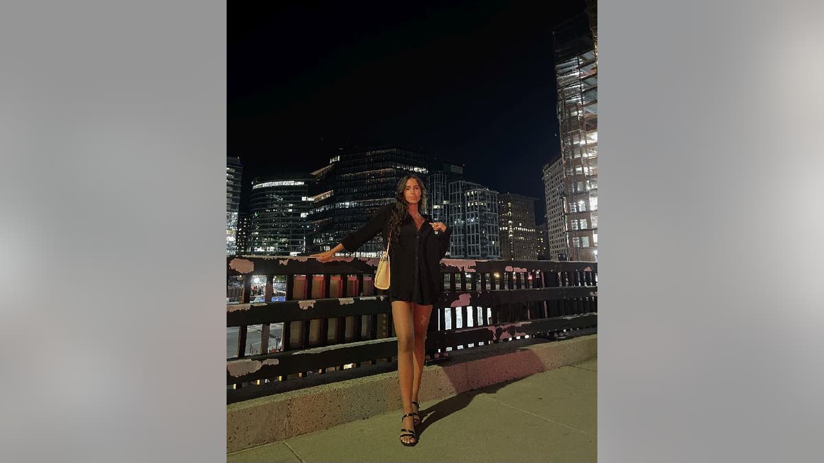 Olivia Downs poses in front of city skyline