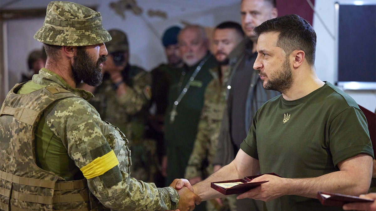 Ukrainian President Volodymyr Zelenskyy hands out an award in Mykolaiv