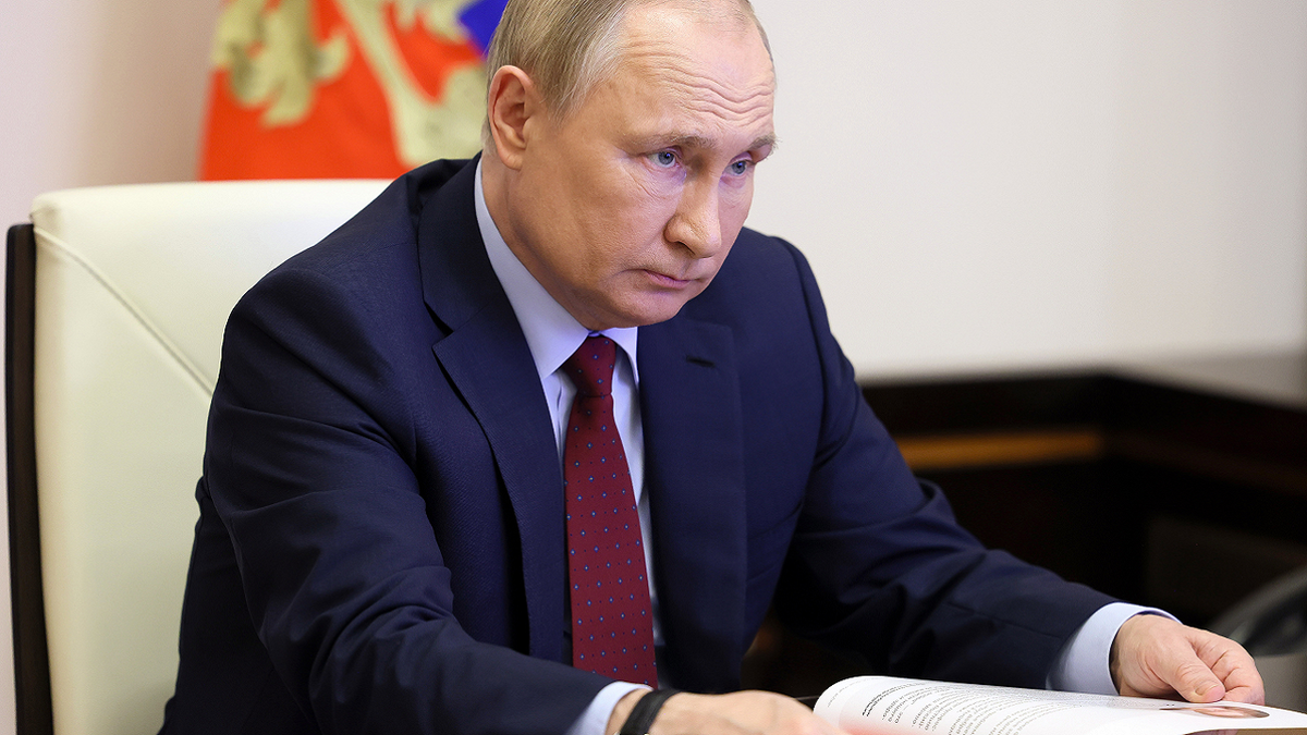 Russian President Vladimir Putin meeting wearing blue suit and red tie in meeting