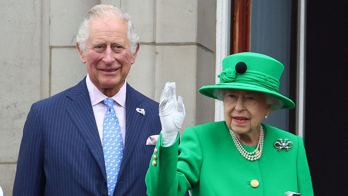 Queen Elizabeth waves on the balcony of Buckingham Palace with Prince Charles during the Jubilee parade
