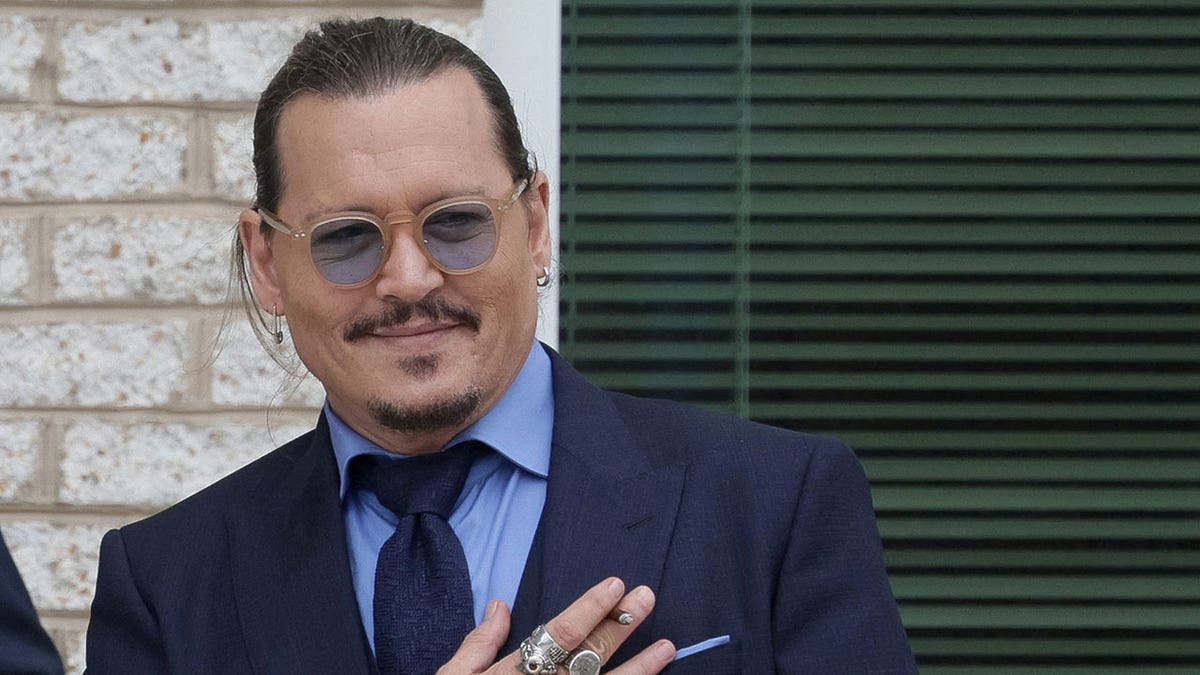Johnny Depp smiles at fans at courthouse