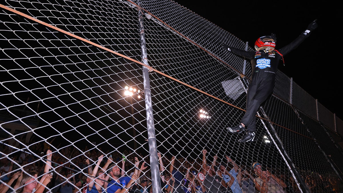 Castroneves climbing fence