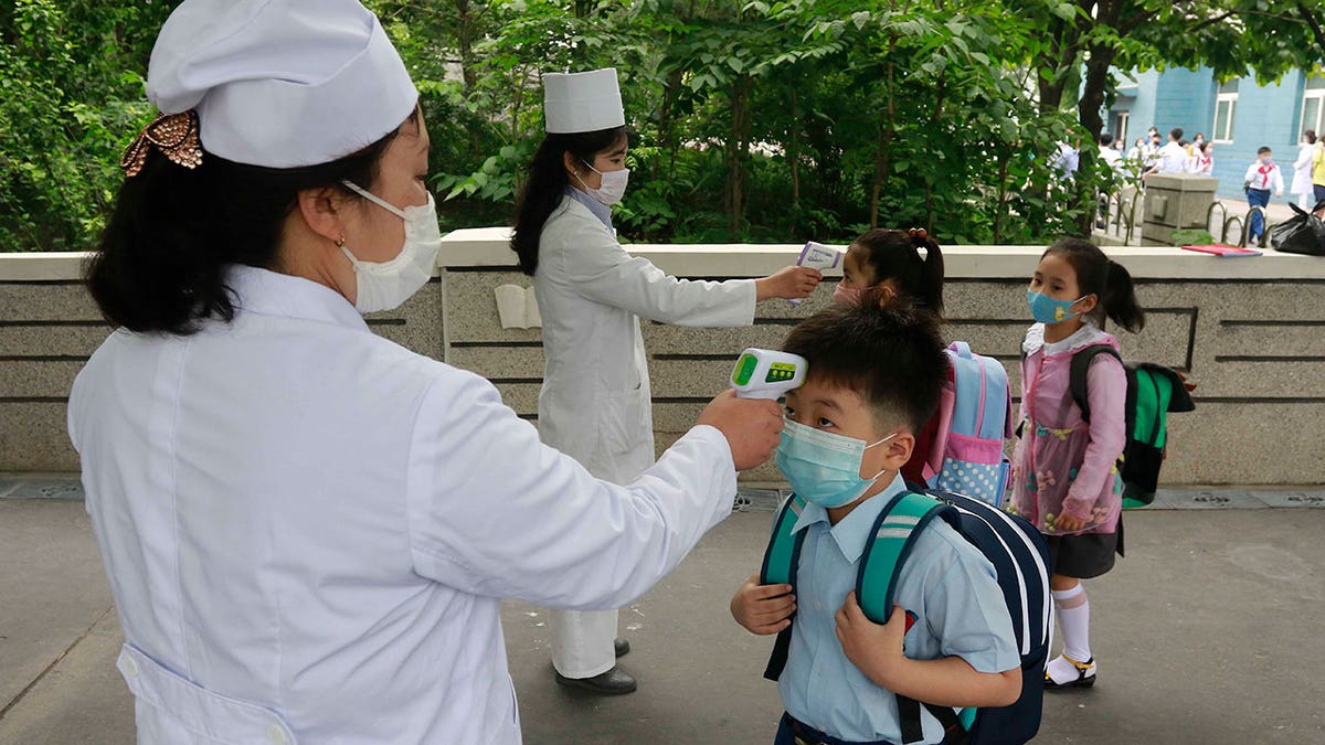 North Korean children get temperature taken 