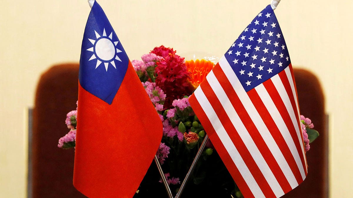 Taiwanese and American flags with flowers behind them