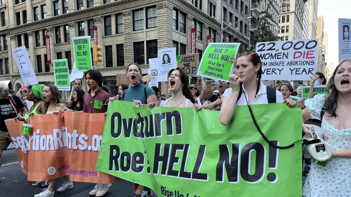 Protesters hold a green sign protesting Roe vs. Wade being overturned