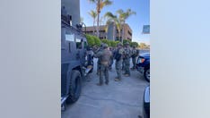 Armed suspect surrenders to police after barricading himself in LA hotel room, taking hostages