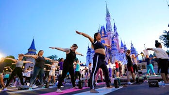 Disney employees celebrate national yoga day in front of Cinderella's Castle