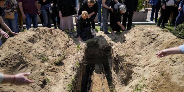 Relatives of Army Col. Oleksander Makhachek mourn during his funeral in Zhytomyr, Ukraine, on Friday, June 3.