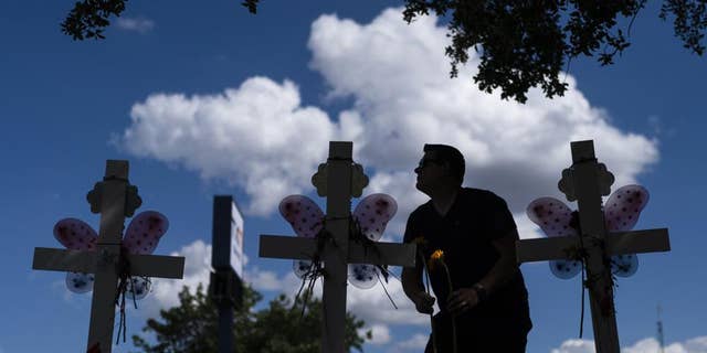 Matthew Solano leaves sunflowers at a memorial to honor the victims killed in the elementary school shooting in Uvalde, Texas, on Wednesday, June 1.