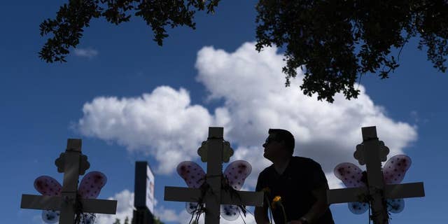 Matthew Solano leaves sunflowers at a memorial to honor the victims killed in the elementary school shooting in Uvalde, Texas, on Wednesday, June 1.