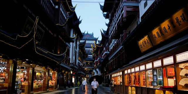 People wearing protective masks walk in Yu Garden amid new lockdown measures in parts of the city to curb the COVID-19 outbreak in Shanghai, China. June 10, 2022.