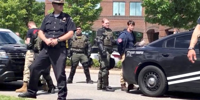 Police officers guard a group of men, who police say are among 31 arrested for conspiracy to riot and are affiliated with the group Patriot Front, after they were found in the rear of a U Haul van in the vicinity of a Pride event in Coeur d'Alene, Idaho, U.S. June 11, 2022, in this still image obtained from a social media video.