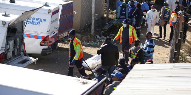 Forensic personnel load the bodies of victims after the death of patrons found at the Enyobeni Tavern, in Scenery Park, outside East London in the Eastern Cape province, South Africa, on June 26, 2022. 